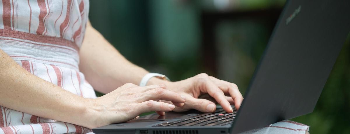 A woman types on a laptop.