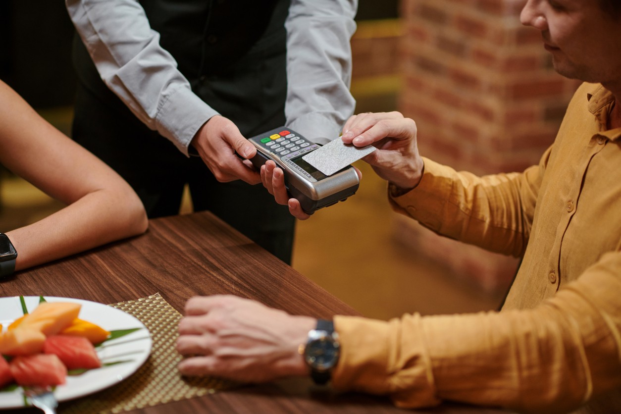 Photo of person paying bill with credit card