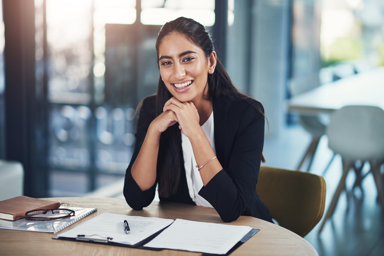 Your professional sitting at desk surrounded by work items.
