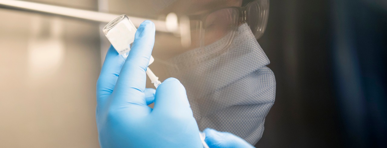 A close up photo of a pharmacist preparing a vaccine dose