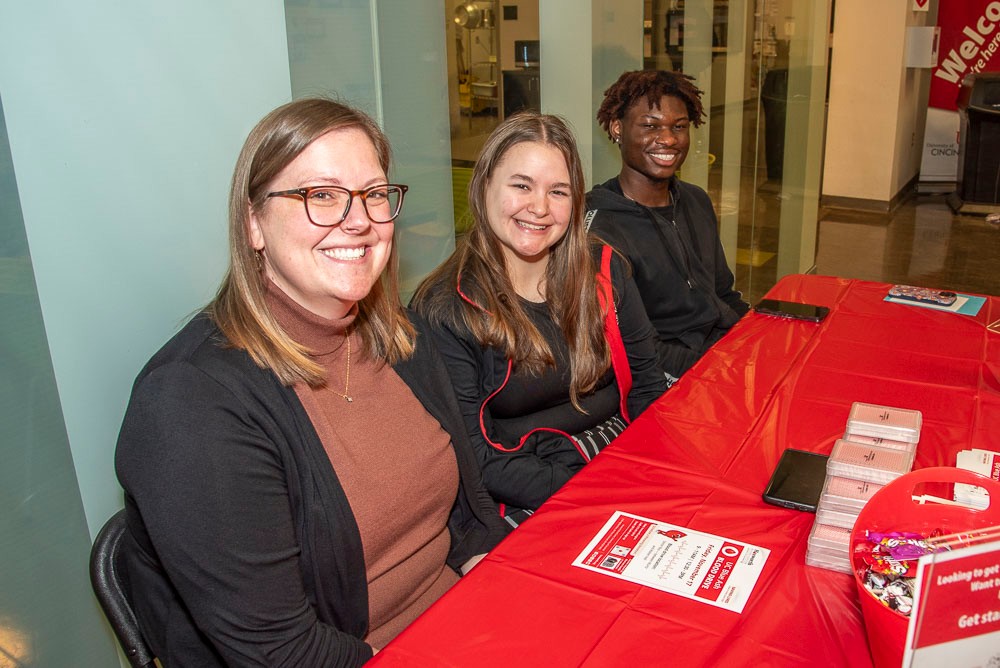 three UC Blue Ash volunteers sitting at a table during event