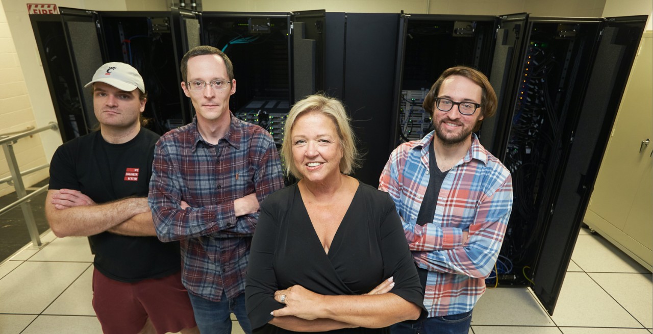 Members of UC's Advanced Research Computing Center pose in front of a supercomputer.