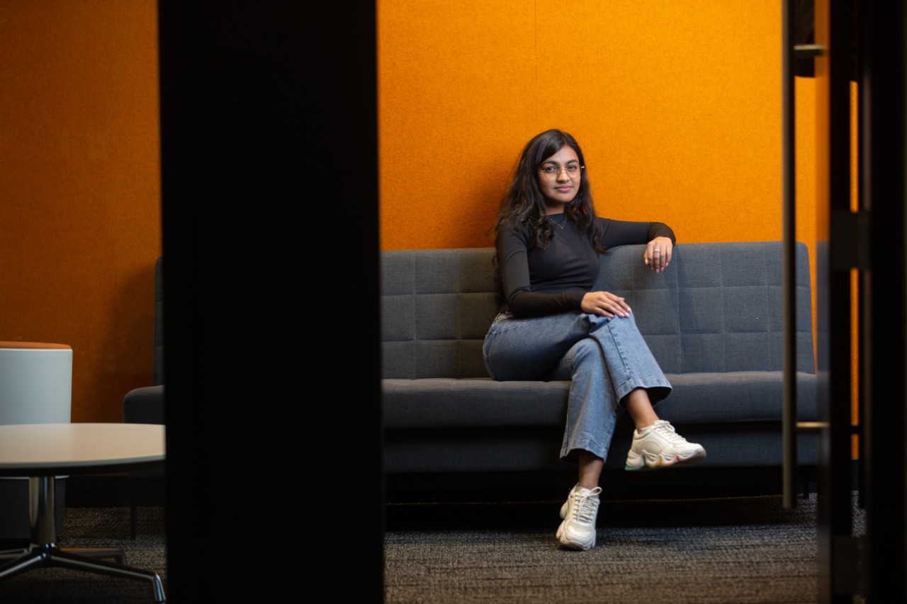 A University of Cincinnati co-op student sits on a couch during work.