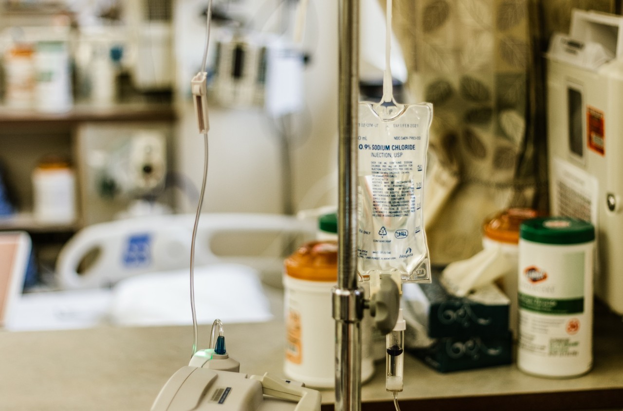 A hospital room with a bed, IV cart and other equipment