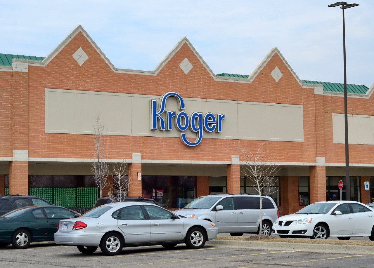image of the exterior of a grocery store with the Kroger name and several cars in the parking lot
