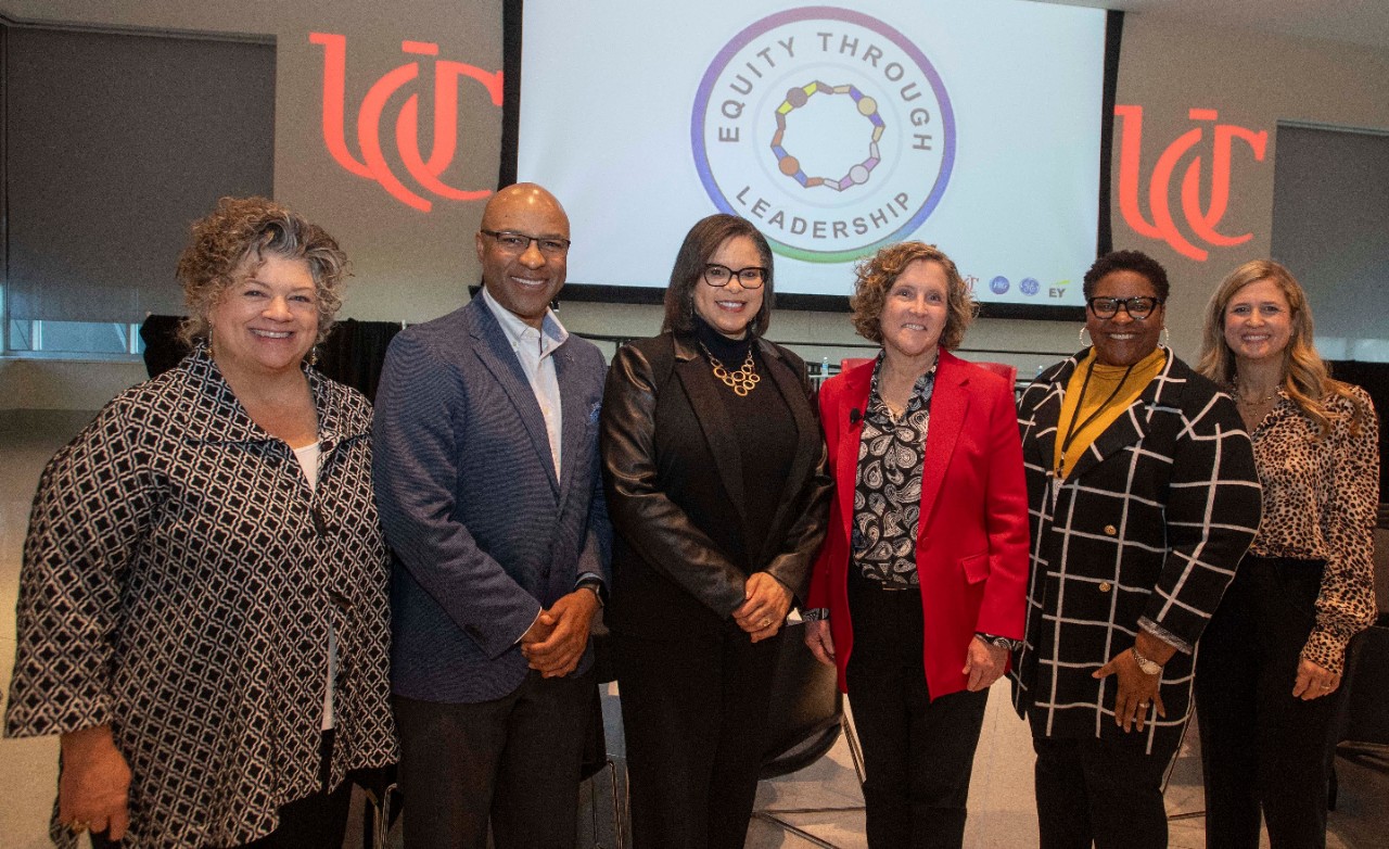 Lindner Dean Marianne Lewis wears a red jacket and stands with panelists from the equity summit at Tangeman University Center.