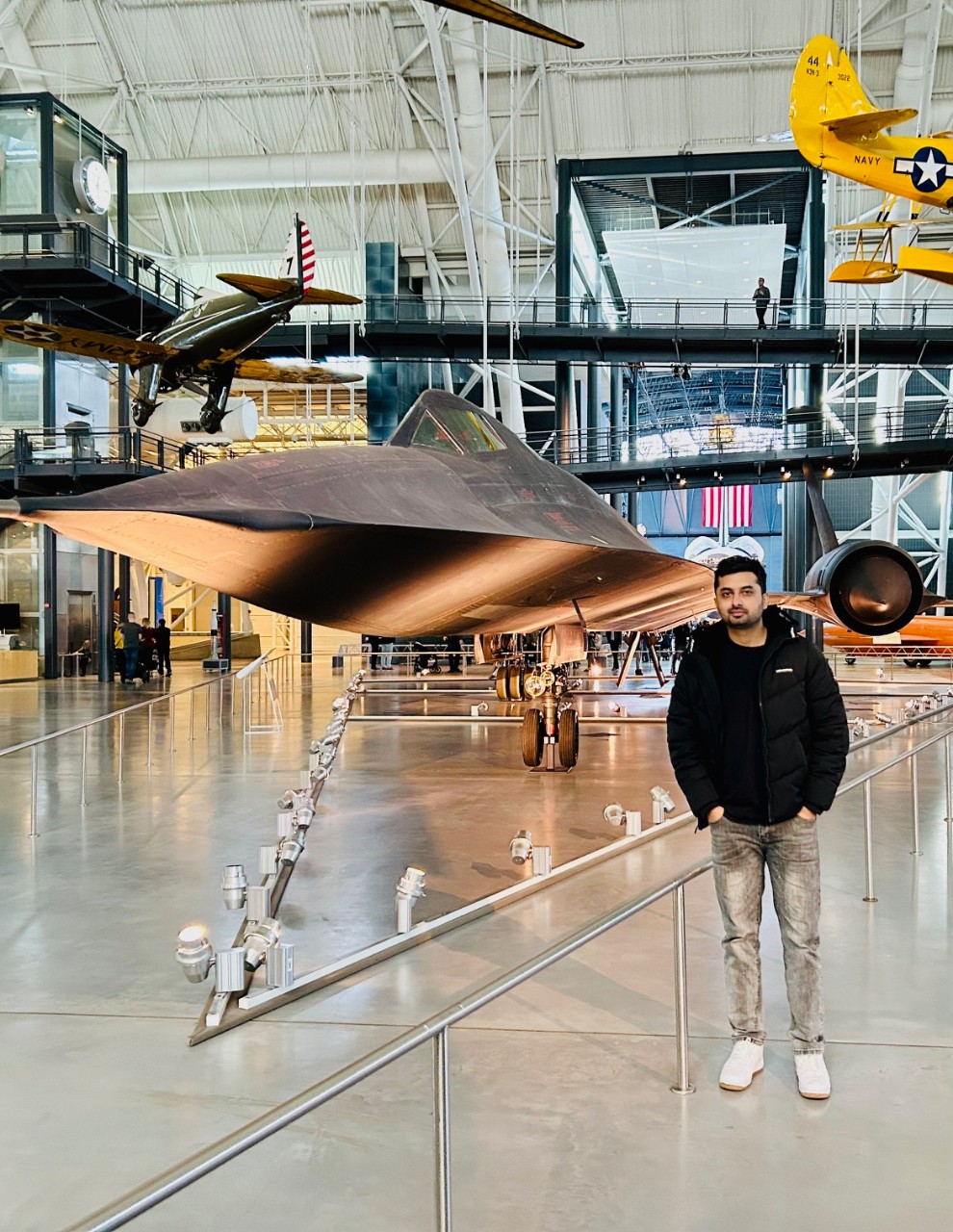 Saugat Ghimire poses in front of a plane at a museum