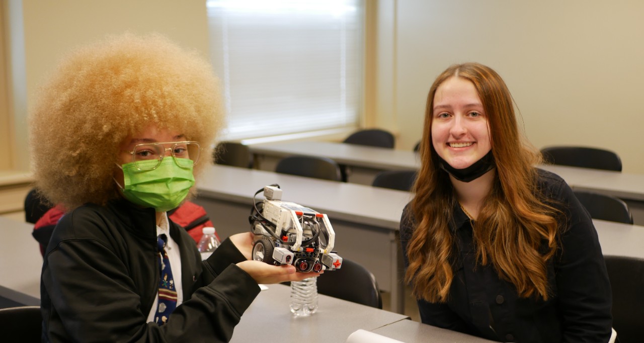 Korman (right) poses with another student holding the competition robot