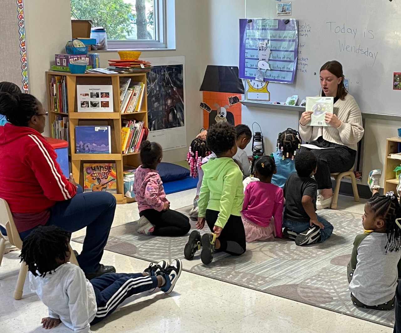 Teacher with a book in a classroom of children