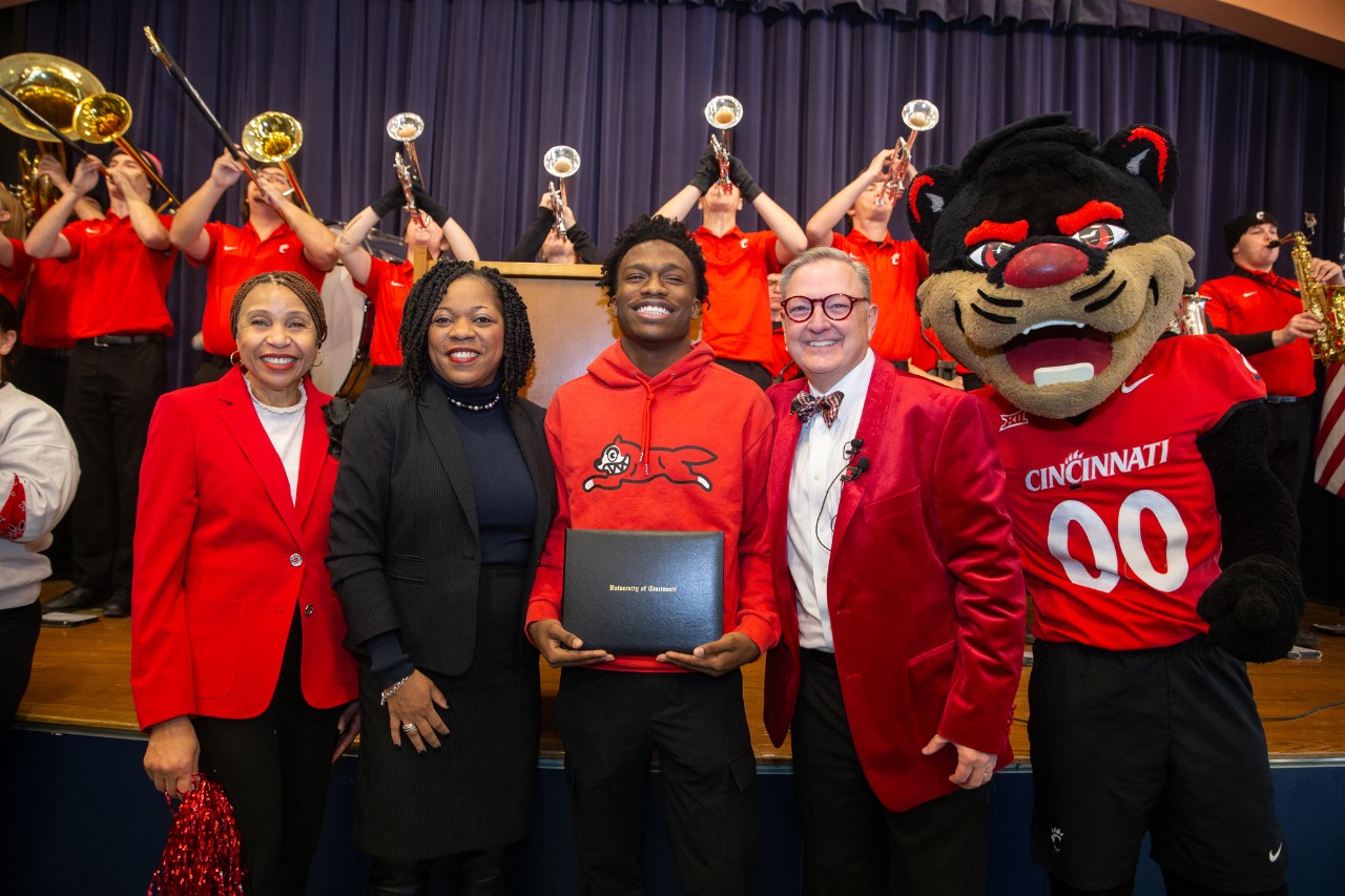 Marian Spencer Scholarship recipient smiles with UC, CPS staff and UC band after being surprised on Decision Day