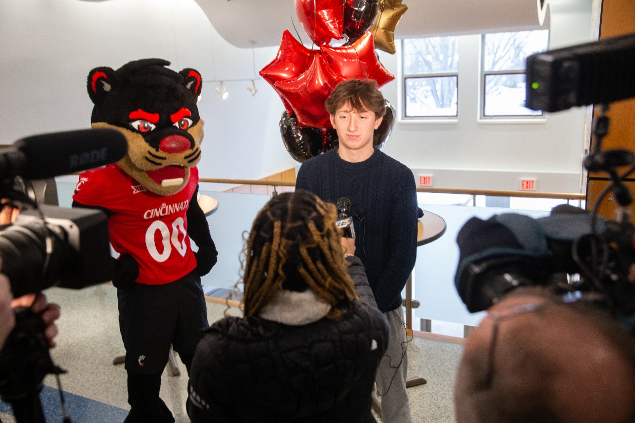 Bearcat Mascot stands to the left as Frances Eckerle is shown facing a television camera