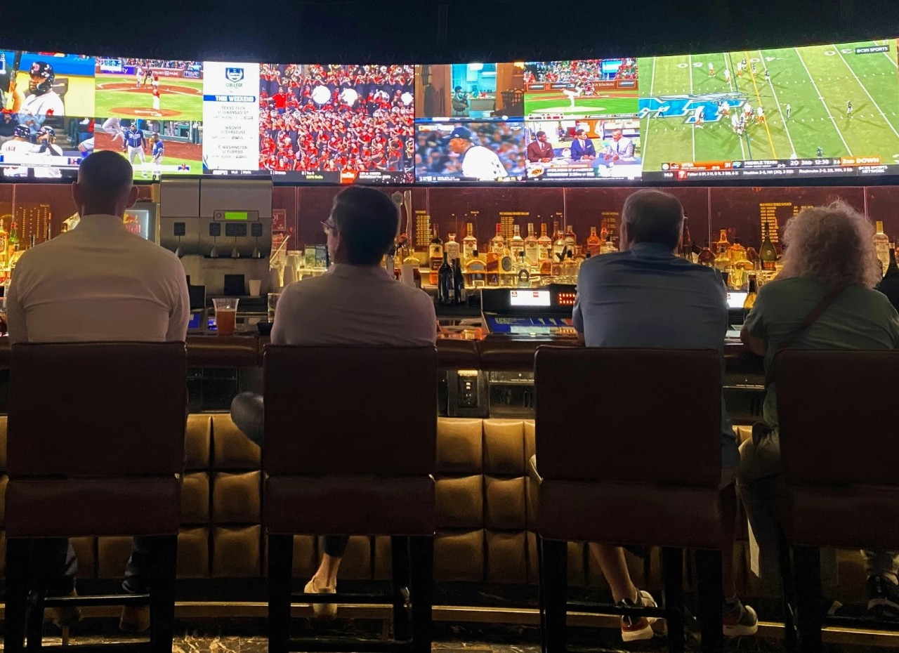 a photo of people sitting in a sportsbook