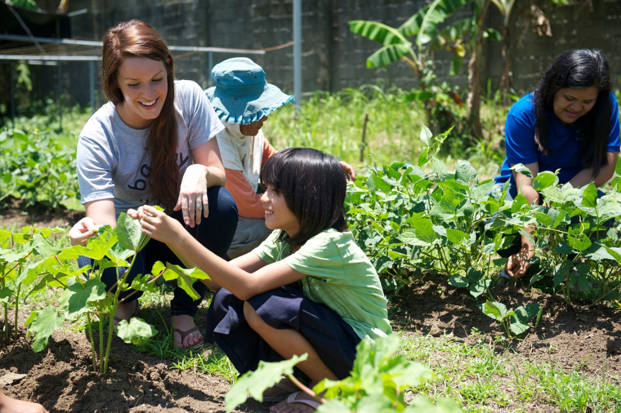 Peace Corps volunteers working in the gardens in Asia