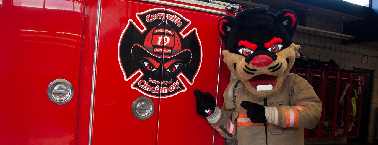 The Bearcat with a fire truck featuring a University of Cincinnati logo. 