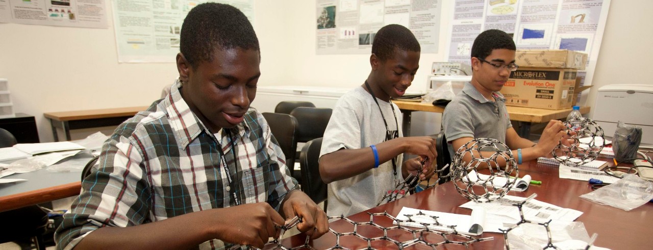 Three male high school students working on an engineering project at UC