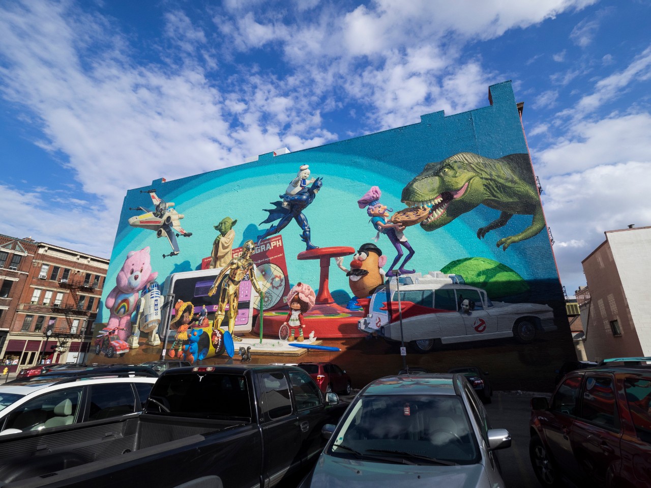 Mural on side of downtown building featuring colorful Hasbro toys