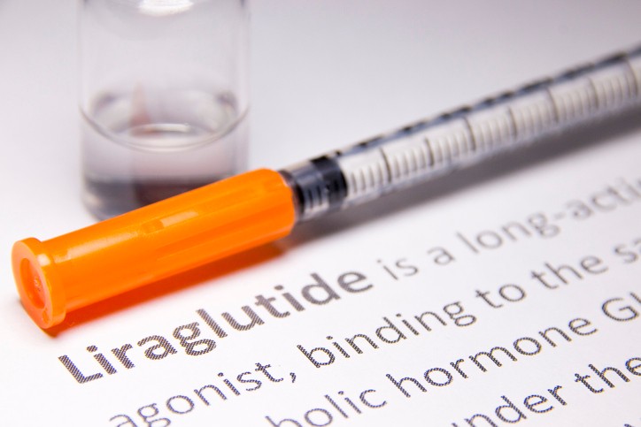 A liraglutide injection pen on top of a paper that says "Liraglutide"