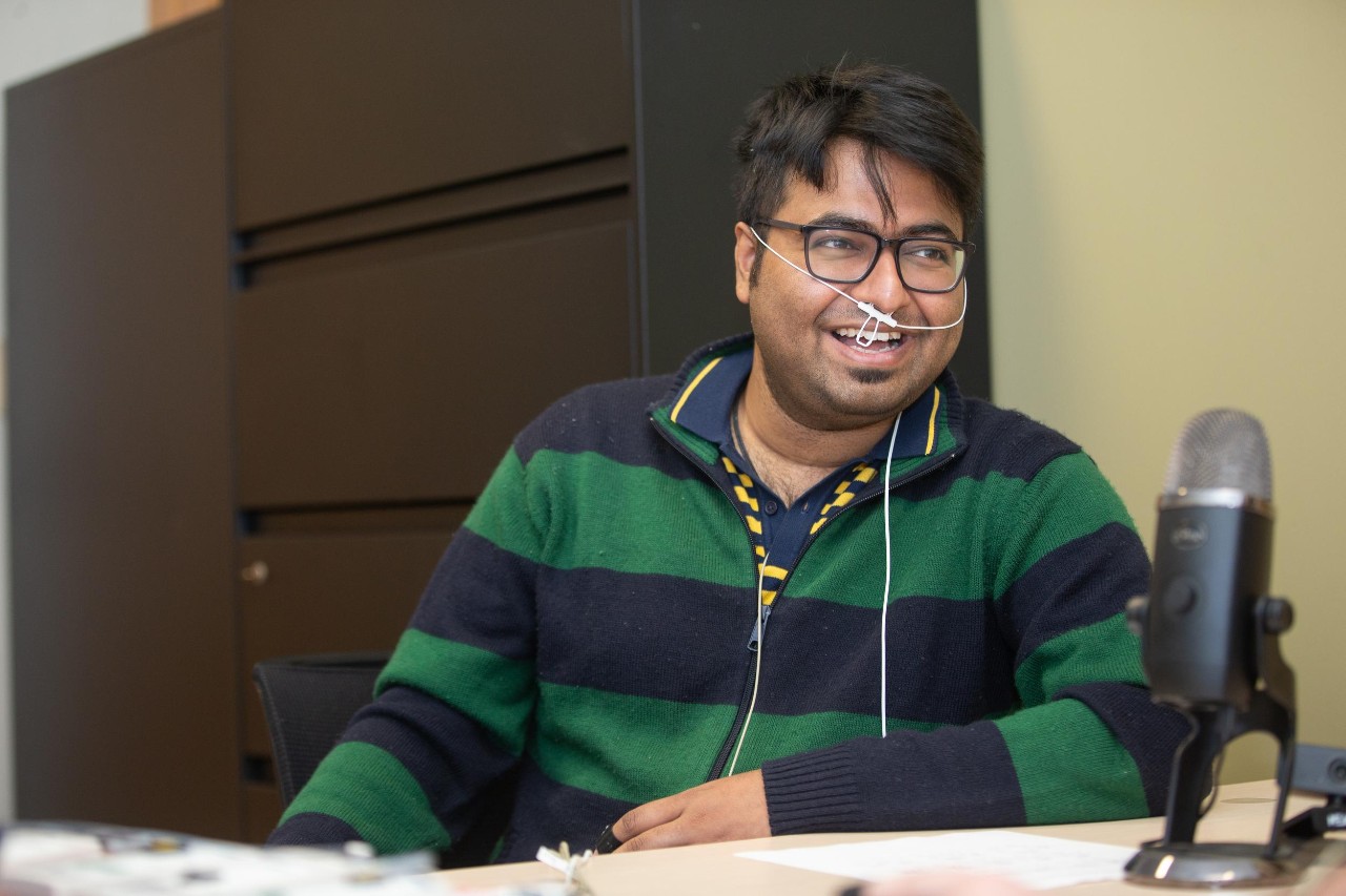 A UC student hooked up to biomonitors laughs while talking to someone off camera.