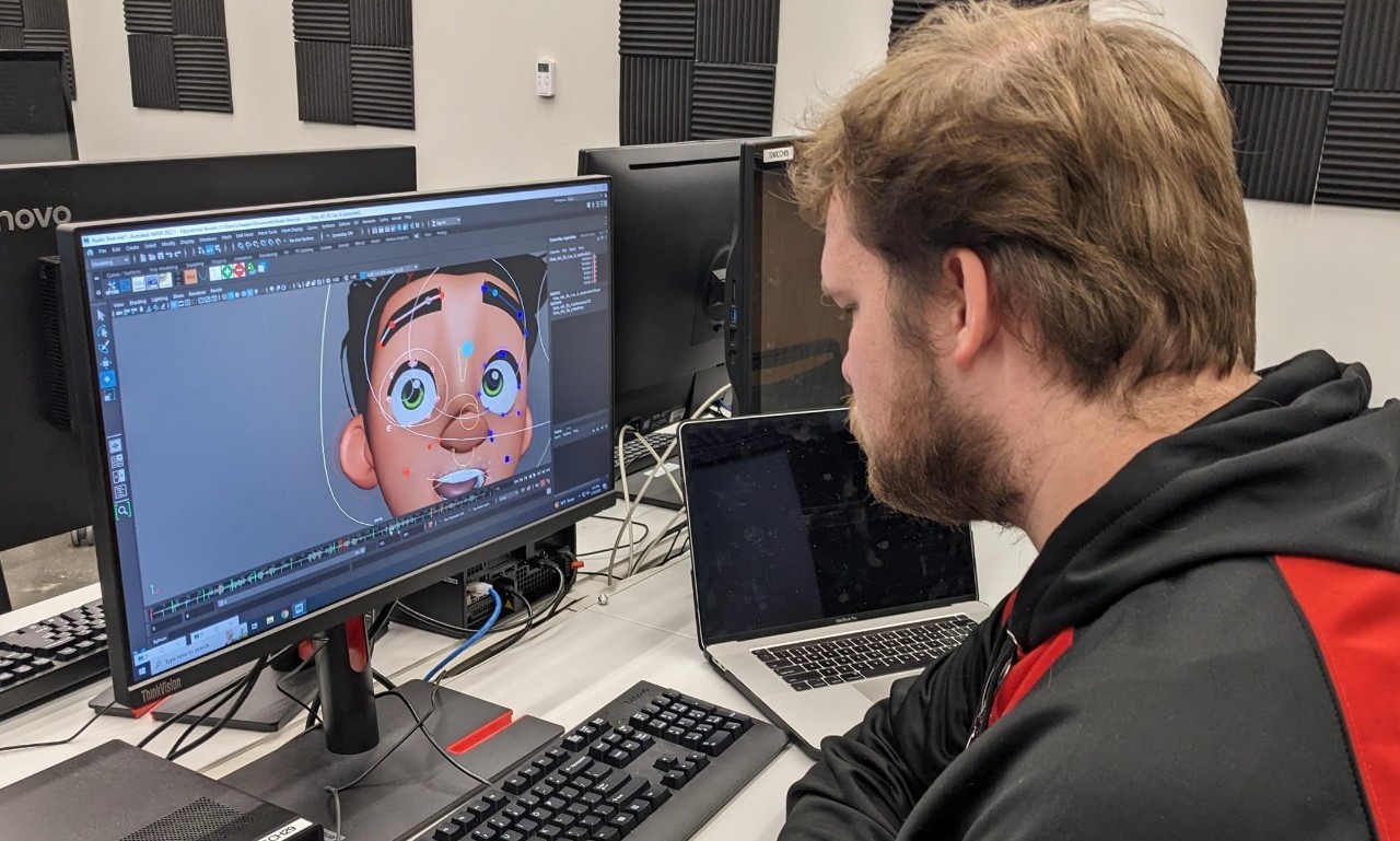 Student working on game animation on desktop.