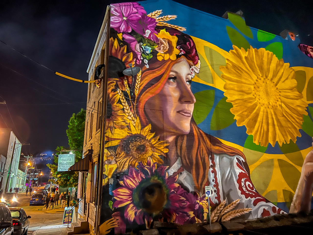 mural of a woman wearing traditional Ukrainian dress on the side of a building.