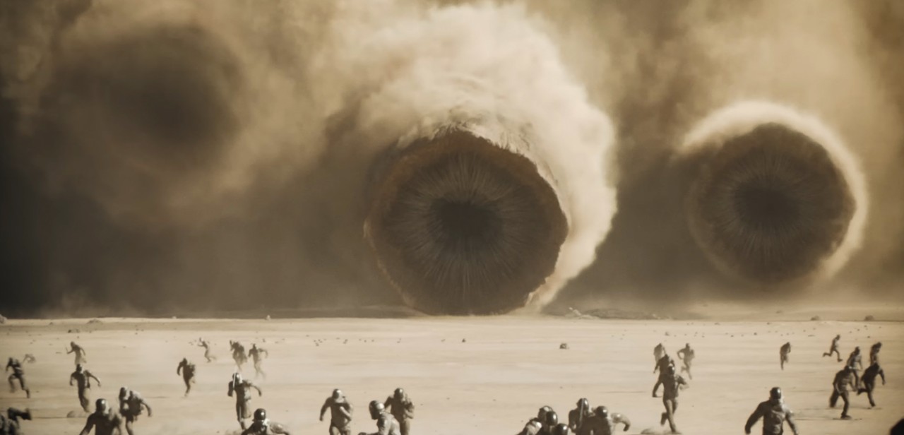 Three sandworms rise from the desert to attack soldiers in a shot from the Warner Bros. movie Dune II.