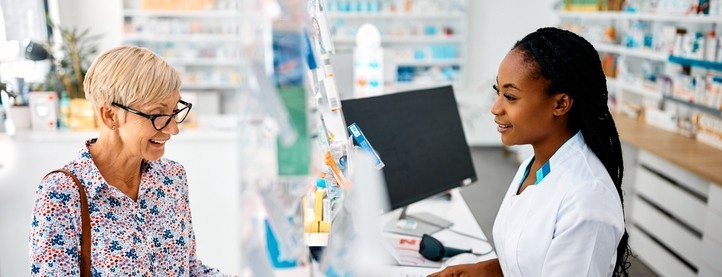 A woman speaks with her pharmacist at the pharmacy counter