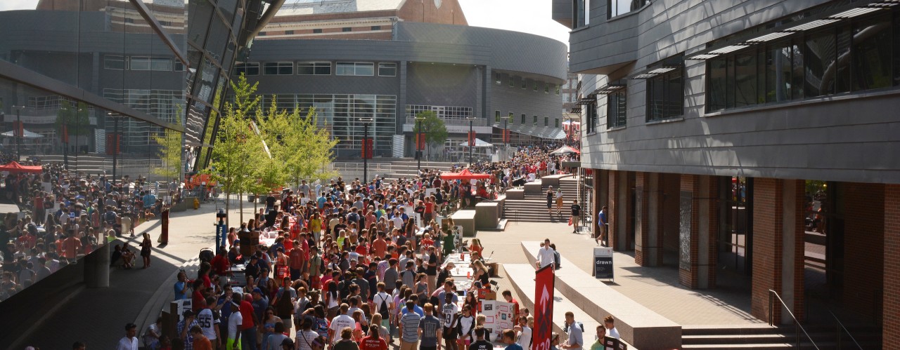 Crowd of students walking along Main Street between UC's Student Center and Nippert Stadium with Tangeman Hall in background.