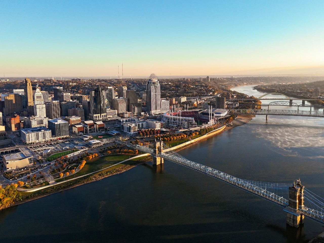 An aerial view of the Ohio River shows the Cincinnati skyline and its bridges.