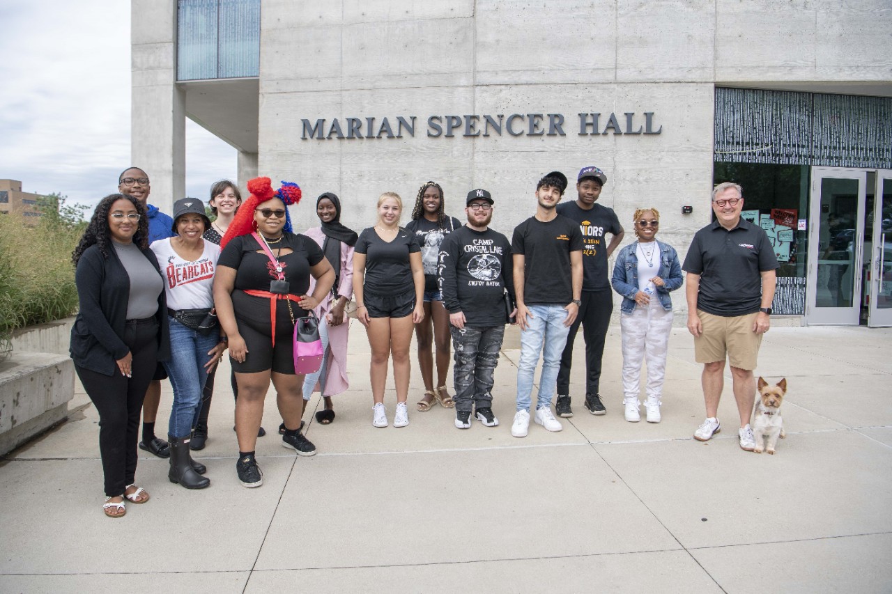 Image shows a dozen people, mainly Marian Spencer Scholars, possed in front of Marian Spencer Residential Hall