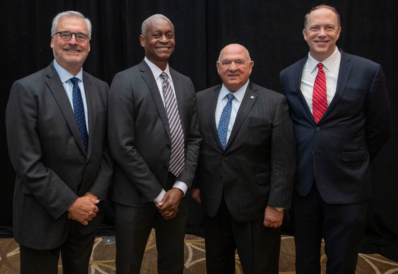 Three men associated with the UC Real Estate Center pose for a picture with the president of the Atlanta Federal Reserve Bank.