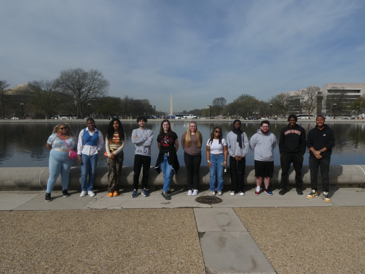 Eleven students from UC stand in front of the Washington Monument in Washington DC