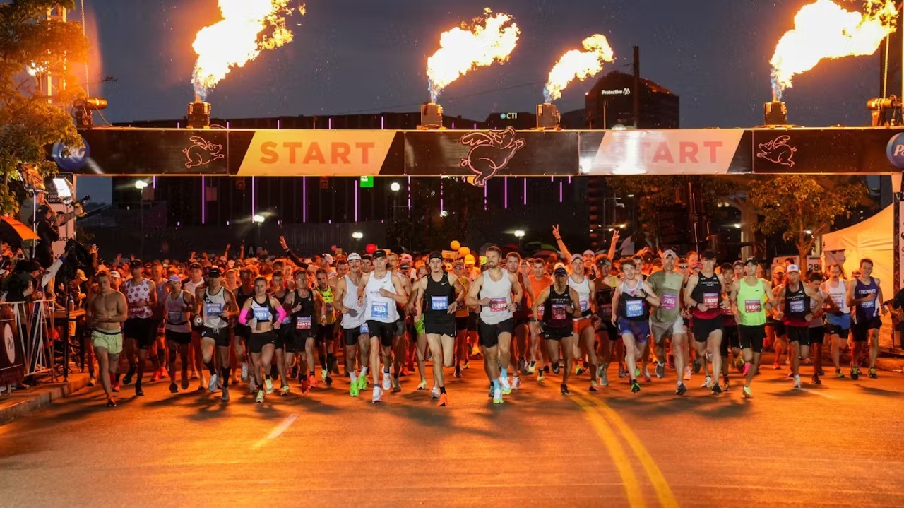 Runners take off from the Flying Pig Marathon starting line in th darkness of early morning