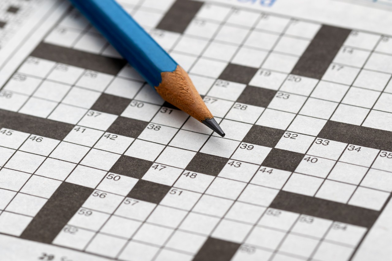 empty crossword puzzle in black and white with blue pencil 