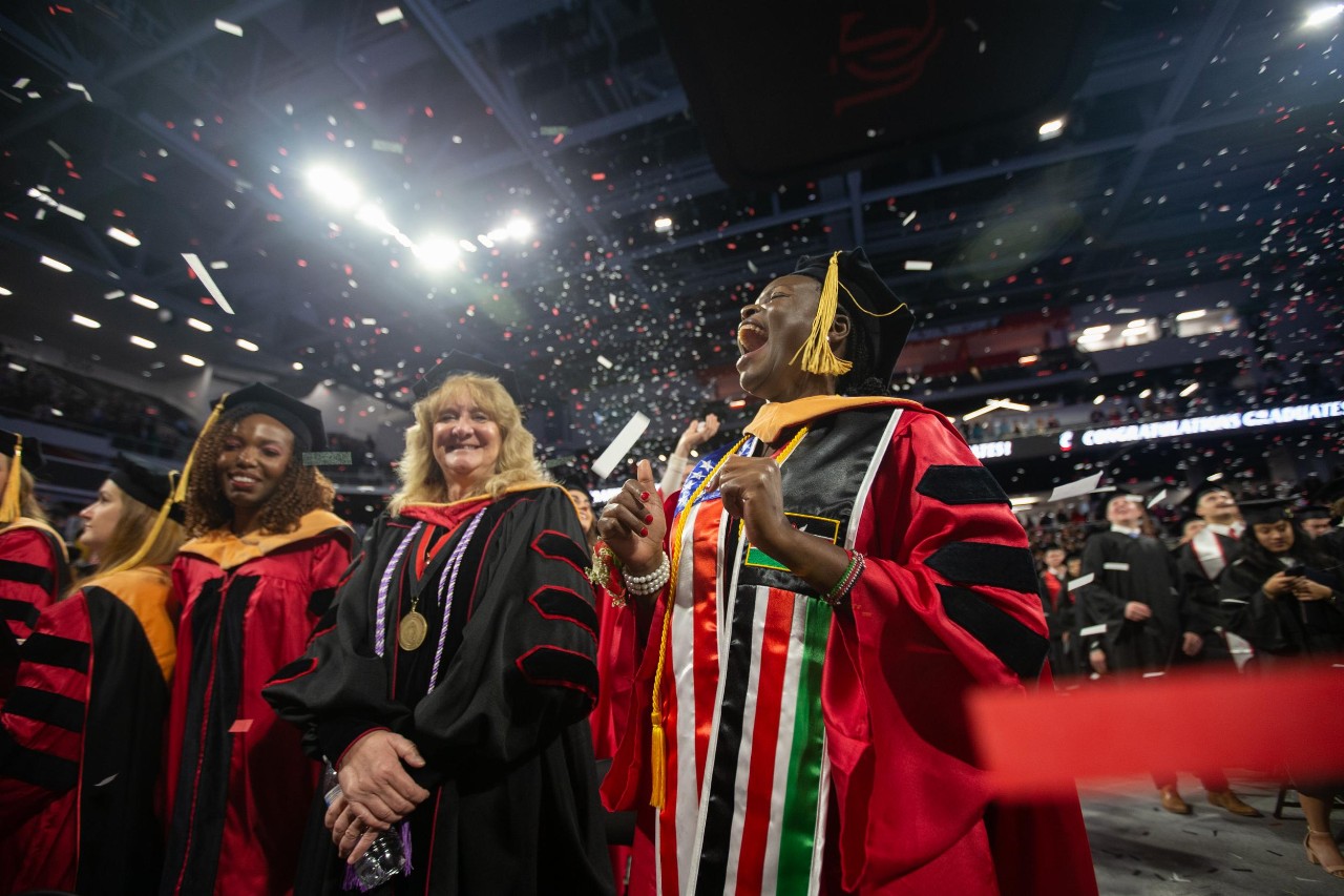 UC students in caps and gowns celebrate commencement at Fifth Third Arena.