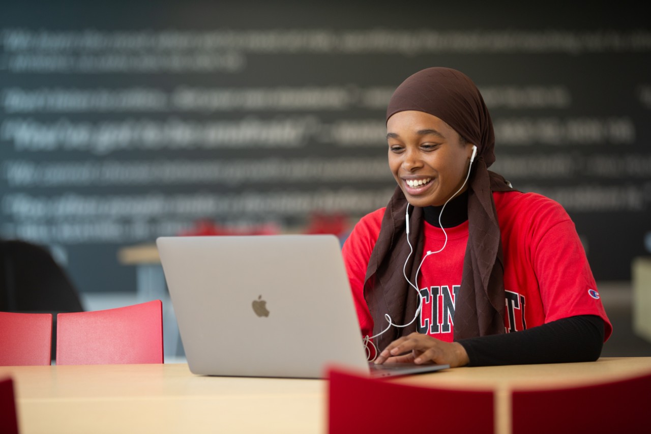 image of a black female student sitting at a laptop typing