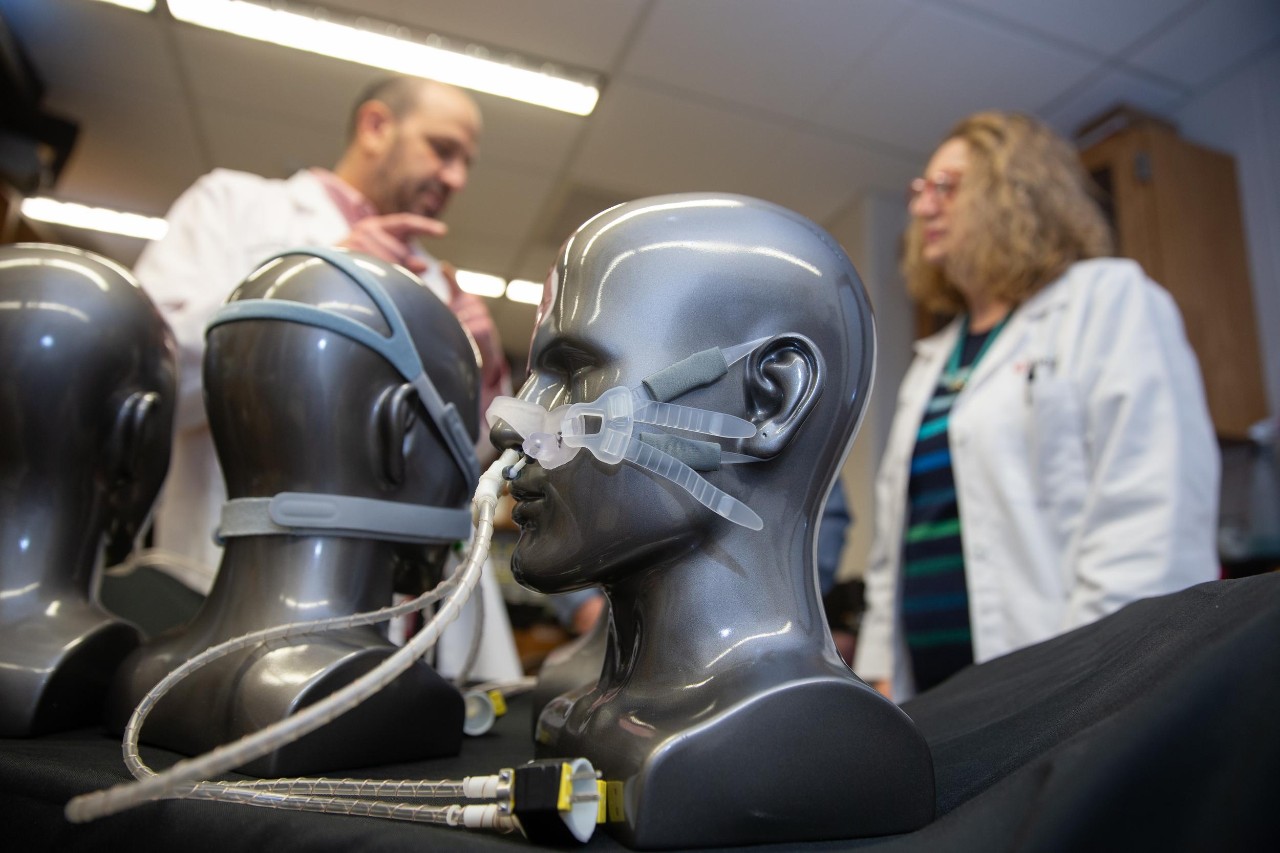 Dr. Liran Oren and Dr. Ann Romaker are shown in the background as a VortexPAP device rests on a mannequin's face