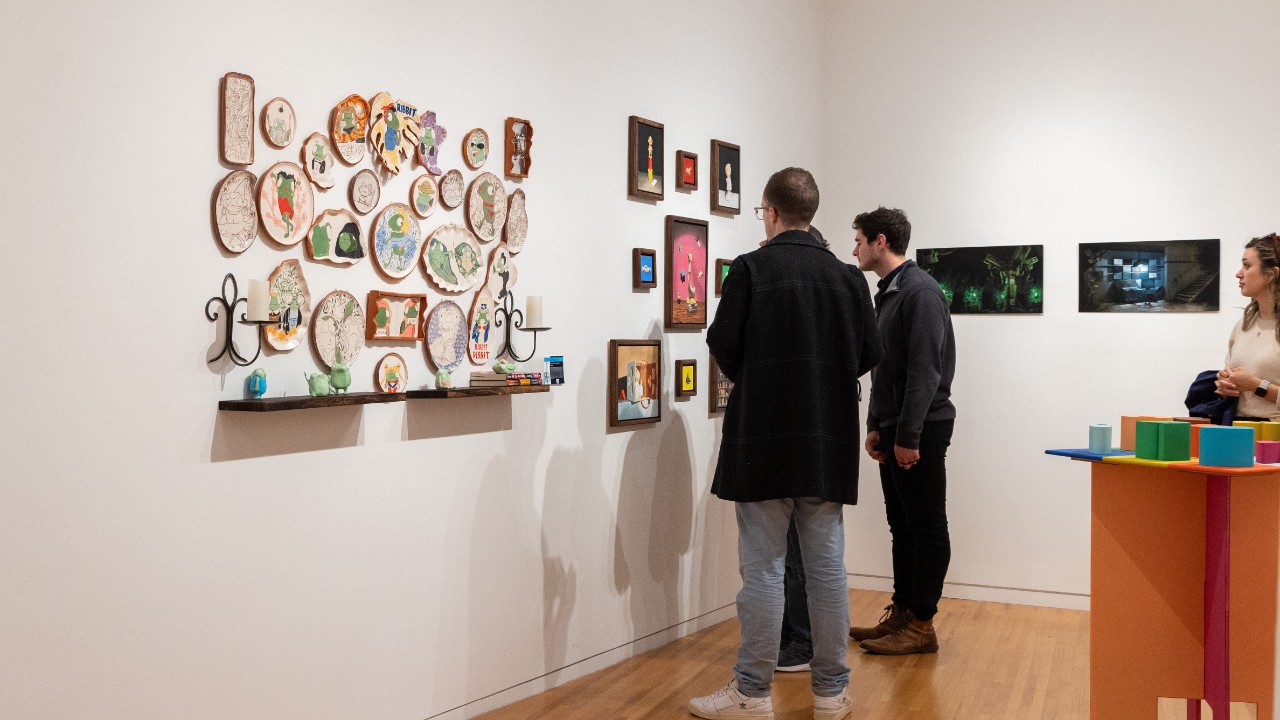 DAAP Gallery during the Opening Reception of DAAPworks. Visitors are checking out a ceramics and photography project from the School of Art.