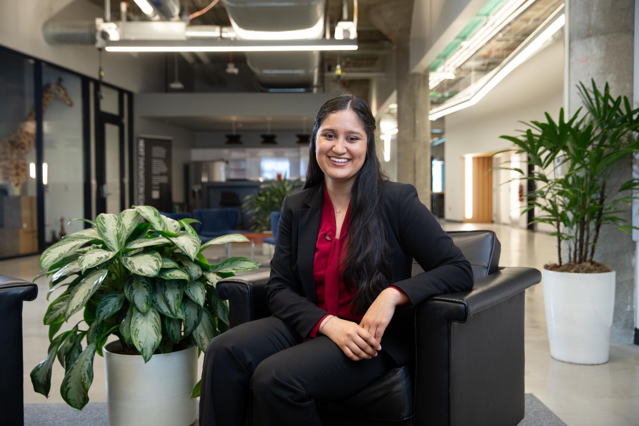 Mallika Desai sits in a chair and smiles in the 1819 Innovation Hub
