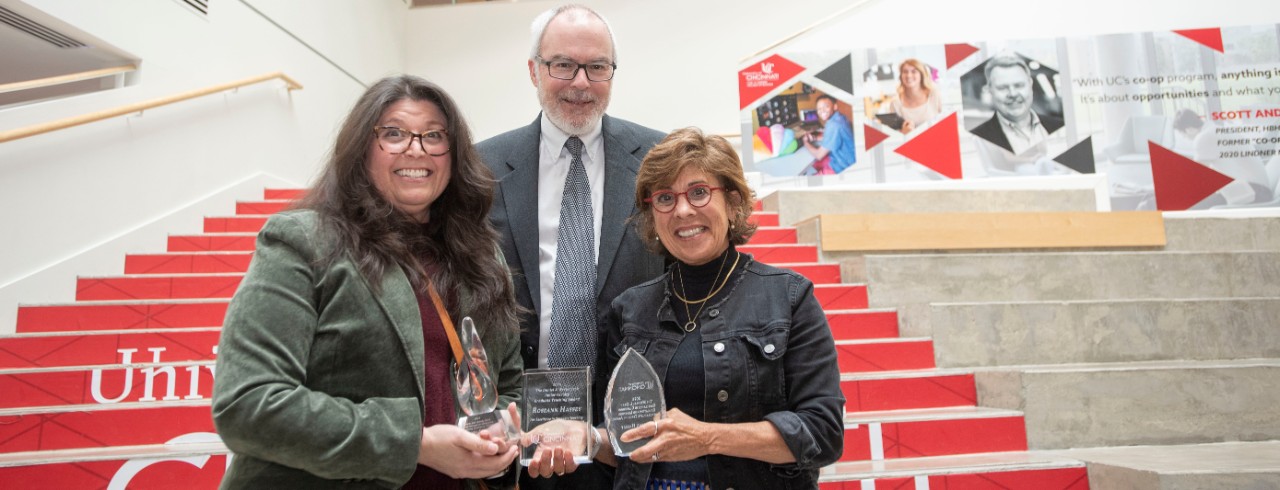 Left to right: Lindner professors Oriana Aragon, holding a glass award, Frank Kardes and Roseann Hassey, holding a glass award