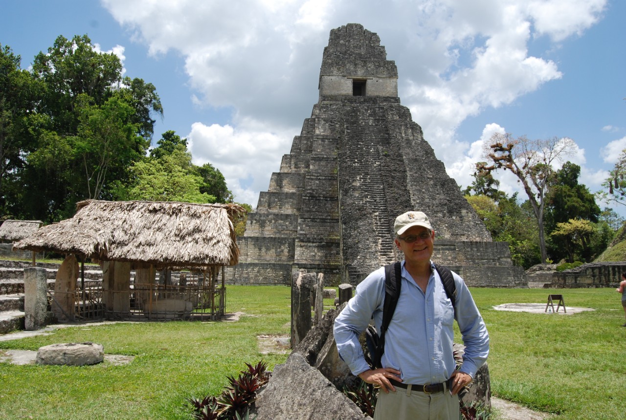 David Lentz poses in front of a temple rising into the blue sky.