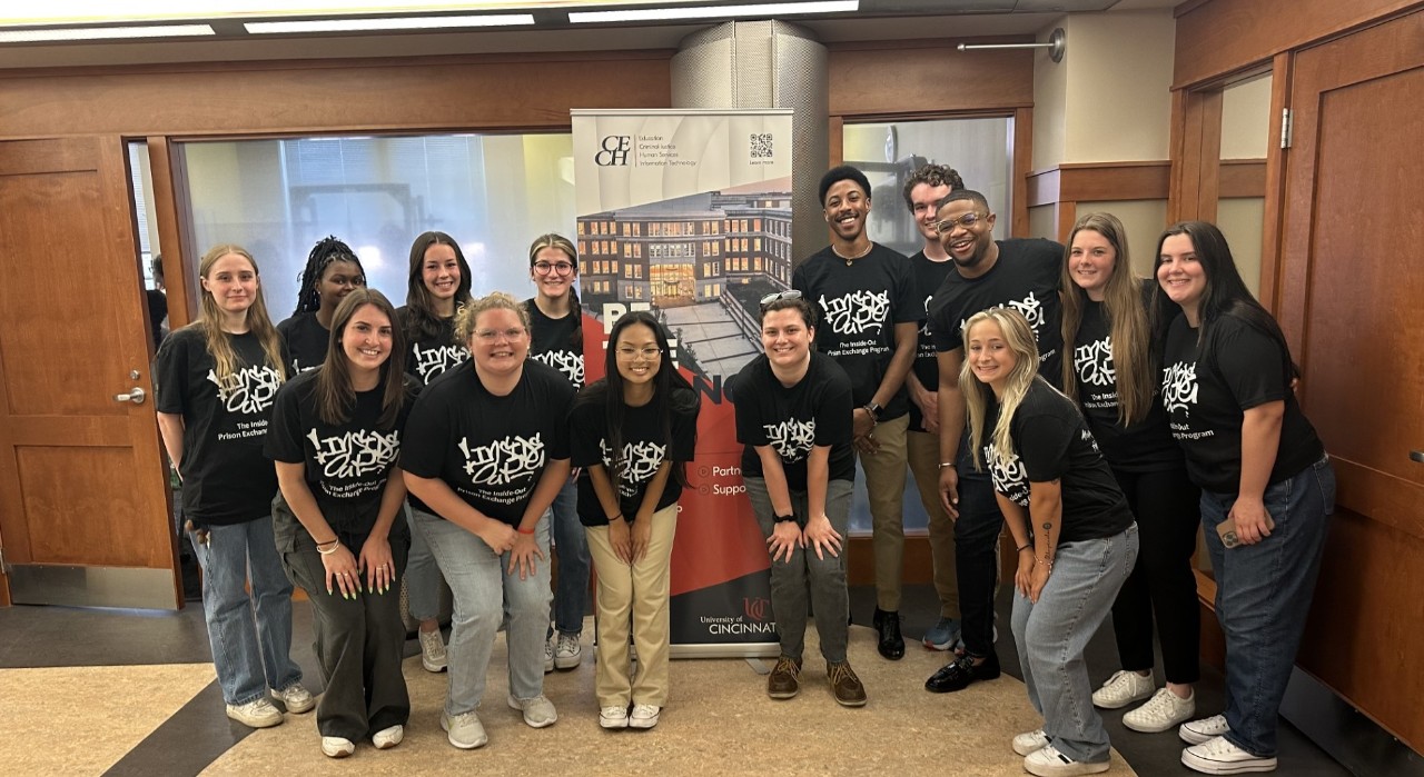 Assistant professor J.Z. Bennett and his eight students wearing black t-shirts that say "Inside-Out" in white letters  