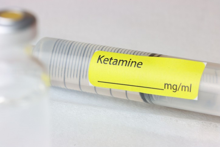 A syringe labeled "Ketamine" next to another unlabeled vial