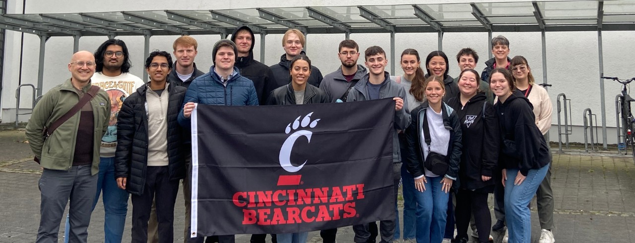 UC group in Germany poses with Cincinnati Bearcats flag