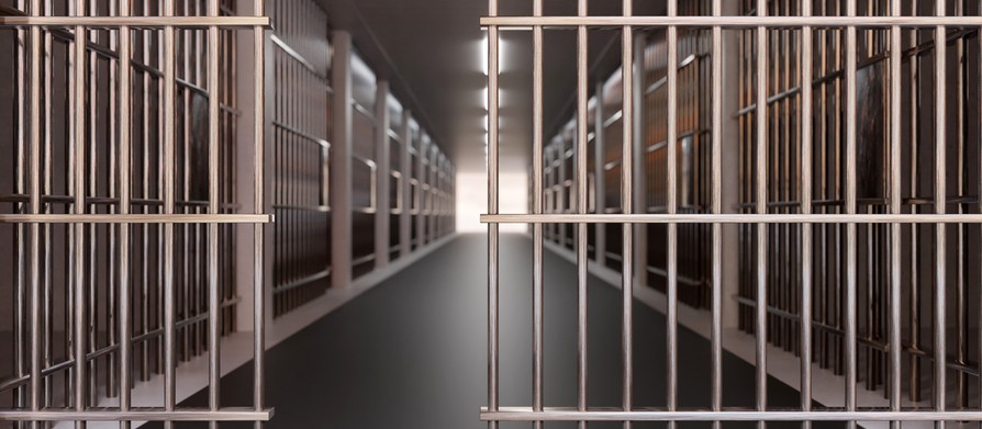 A prison building corridor, jail cell and open metal bars door