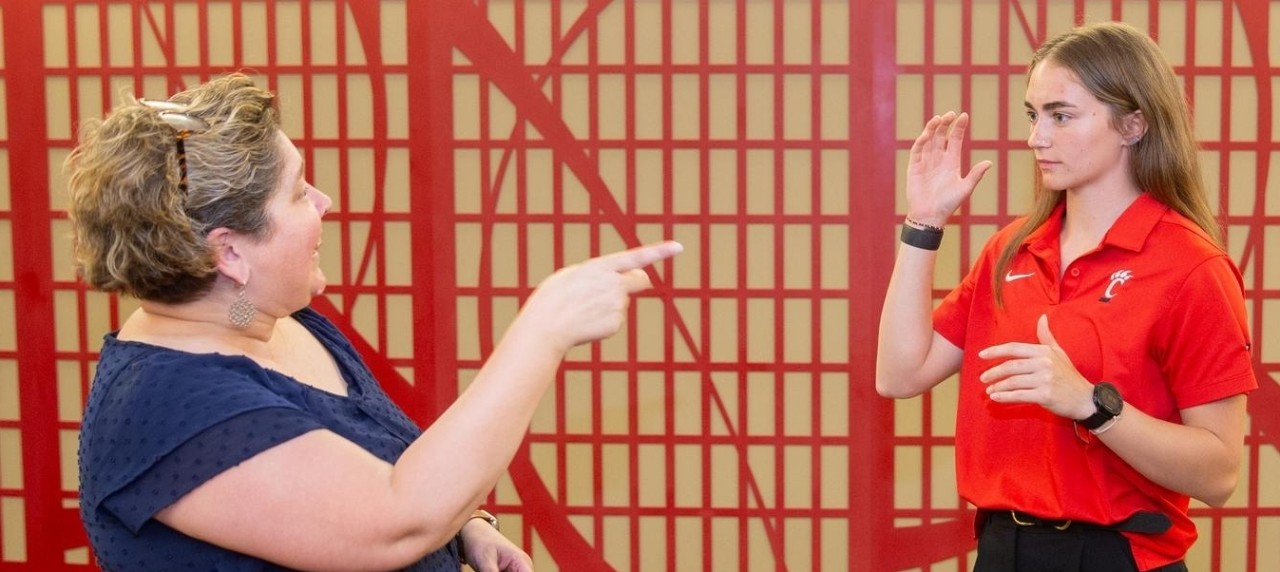 A deaf ASL instructor signing with a student