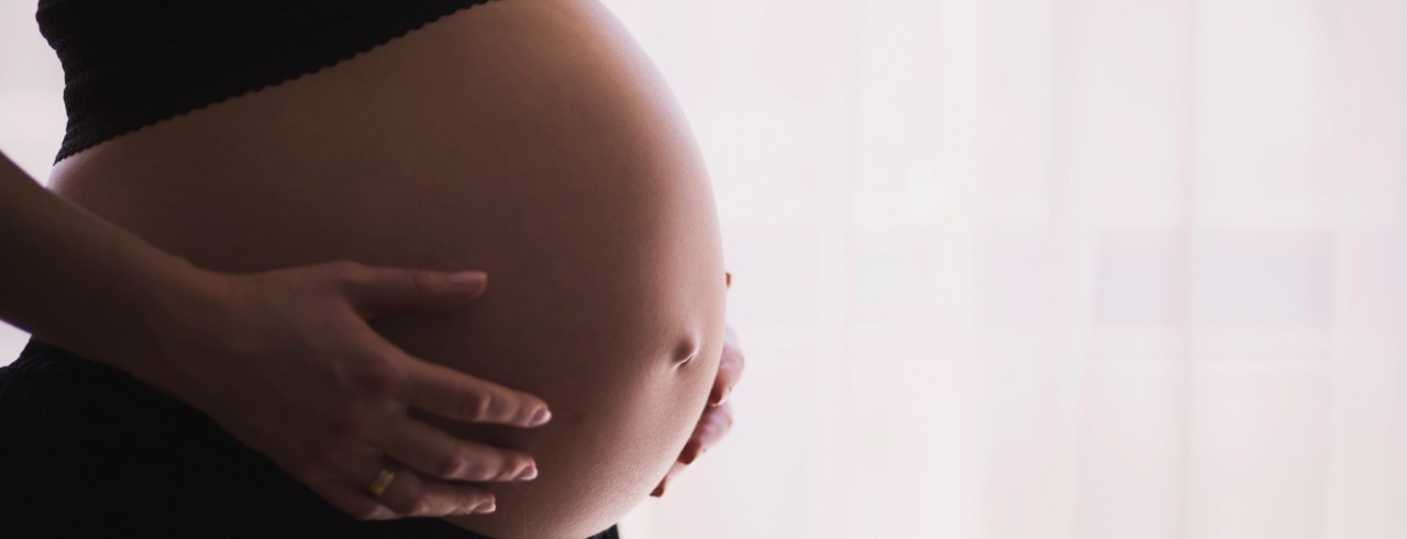 Woman's hands on her pregnant stomach