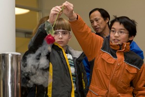 Two boys enjoys freezing a rose in liquid nitrogen.