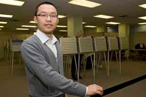 Muer Yang in front of voting machines