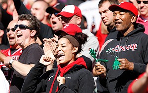 University of Cincinnati fans cheer on the Bearcats in their red and black gear.