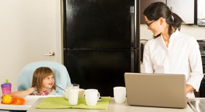 Image of a mom working at home with a child nearby